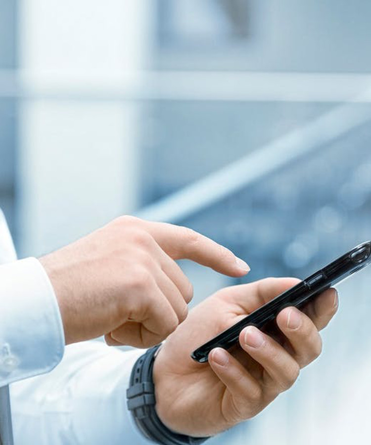 A hand points at a cell phone.