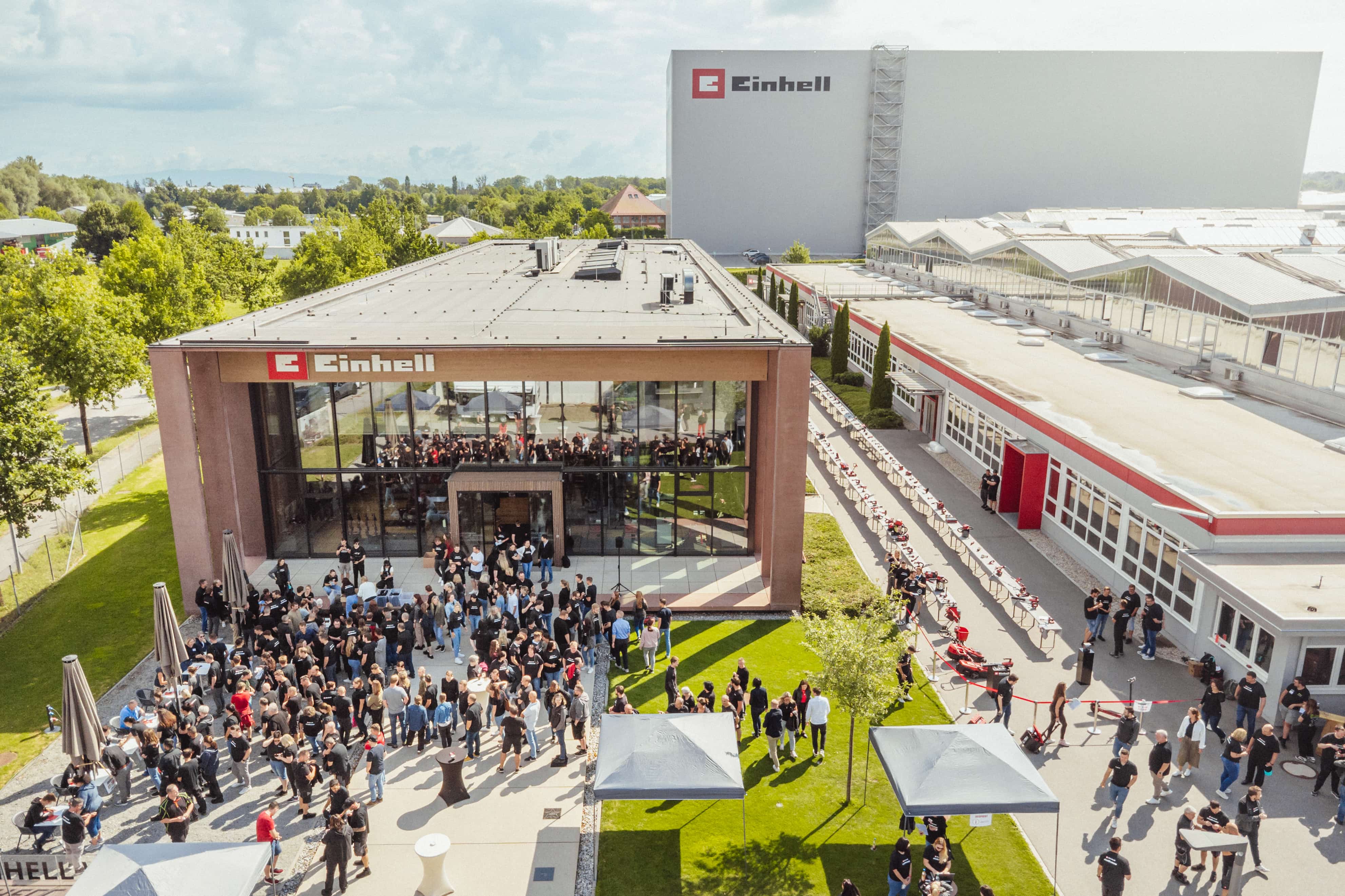 Aerial view of the einhell.livepany site with many gathered people and set-up tool stations.