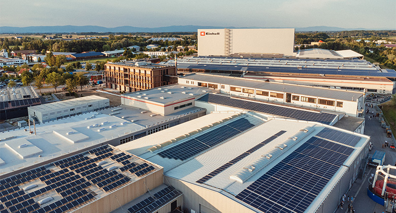 Aerial view of the einhell.livepany premises with numerous factory halls whose roofs are extensively covered with photovoltaic systems.